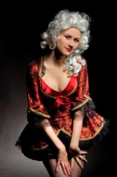 Young woman in baroque custome against dark background