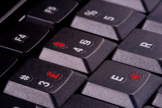 Computer keyboard with currency symbols (GB Pound, US Dollar and Euro) in Red