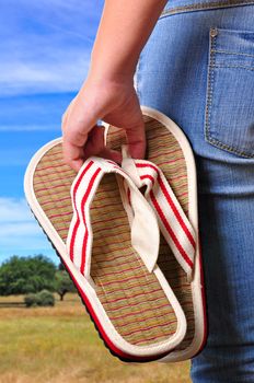 Girl holding sandals on the first day of vacations at the country.