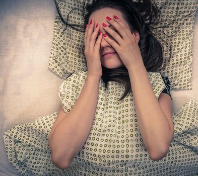 Young woman in the bed in bright light