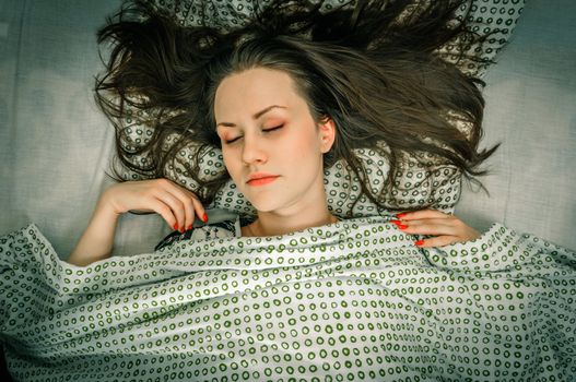 Young woman in the bed in bright light