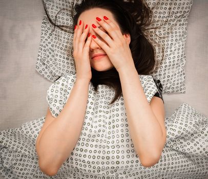 Young woman in the bed in bright light