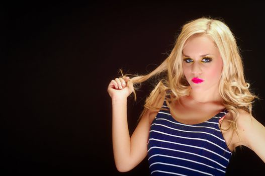 Closeup of a blond woman posing against dark background