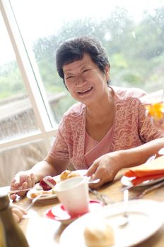 Asian senior woman enjoying her dining with family in a restaurant