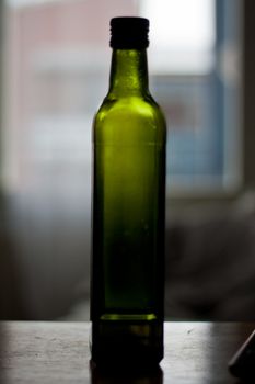 Closeup macro shot of a green virgin oil bottle.