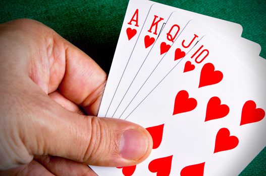 Hand holding a Royal Flush poker card sequence