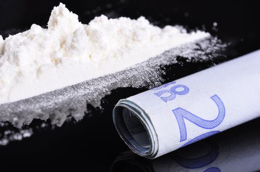 A bank note next to a line of cocaine, ready to be snorted