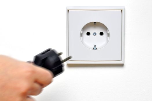 Hand connecting a plug to a socket