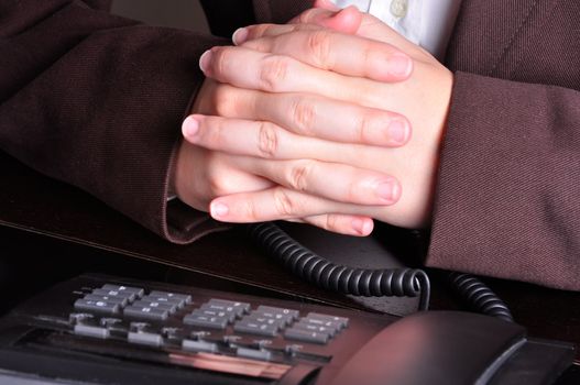 Businessperson with hands crossed waiting for the phone to ring