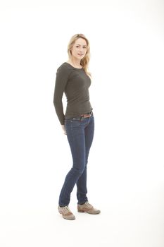 blonde woman wearing a long sleeve shirt with her hands on her back pocket standing on a white seamless background