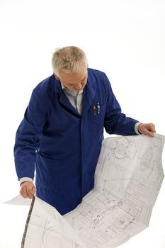 Engineer in a blue coat consulting a large open blueprint drawing which he is holding in his hands