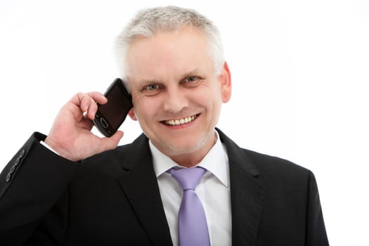 Smiling middle-aged businessman in a suit using a mobile phone isolated on white