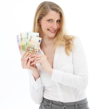 Smiling successful woman showing her winnings of multi-denominational euro banknotes fanned out in her hands