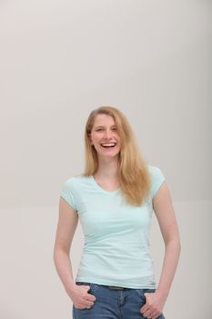 Studio shot of smiling blonde woman on gray background with copy space