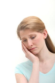 Blond woman with toothache on white background