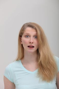 Young female with blond hair and astonished face expression