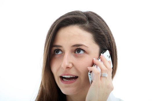 Attractive young woman in deep conversation on her cellphone or mobile phone as she chats to friends