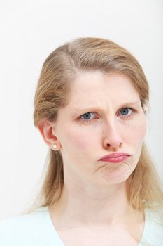 Pretty young blonde girl shows her disagreement with a facial expression