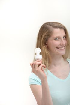 Smiling woman holding eco friendly light bulb
