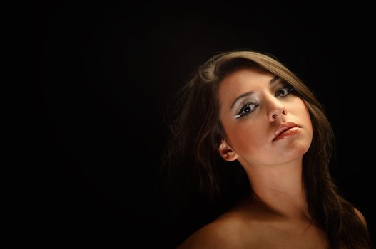 Girl with long hair in the studio against dark background