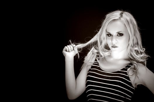 Closeup of a blond woman posing against dark background