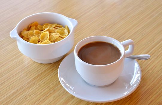Cup of black coffee and cornflakes on the  table
