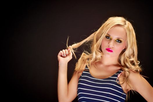 Closeup of a blond woman posing against dark background