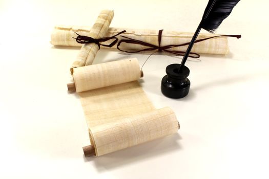 papyrus scrolls with quill and inkwell on a light background