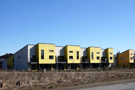 Modern apartment house on a background of a green grass and trees