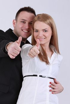 Successful young couple with thumbs up.