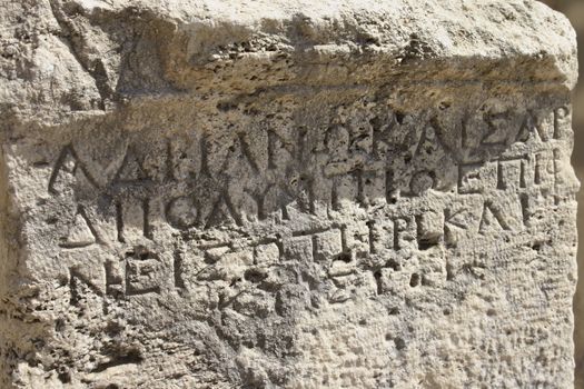 Ancient Greek writing carved on old limestone surface