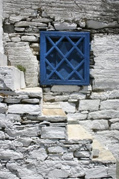 Blue greek window shutters stone stairs and old stone wall