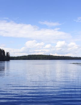 Calm blue lake with blue sky white clouds reflection background