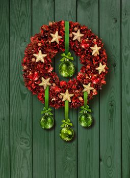 Red Christmas garland with green glass balls on old wooden door