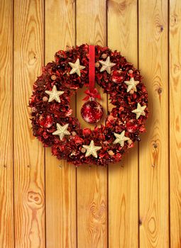 Red Christmas garland with glass balls on old wooden door