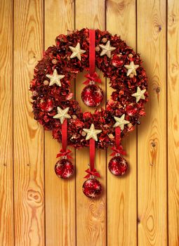 Red Christmas garland with glass balls on old wooden door