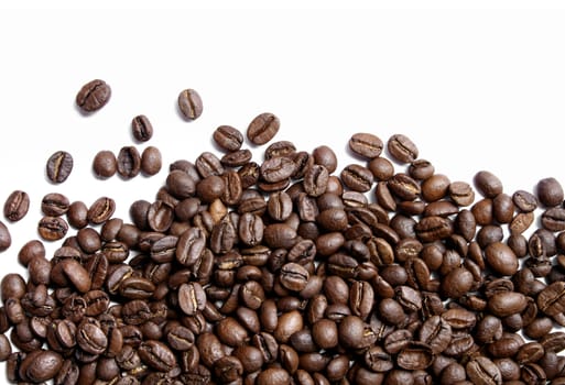 Roasted dark brown coffee beans on white background