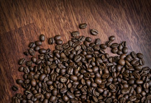 Roasted coffee beans on dark brown wooden background