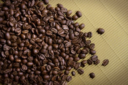 Roasted dark brown coffee beans on golden background