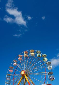 Colorful Ferris wheel against blue summer sky background