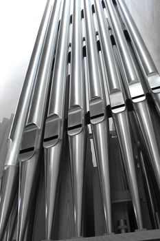 Modern steel organ pipes in a row descending close-up