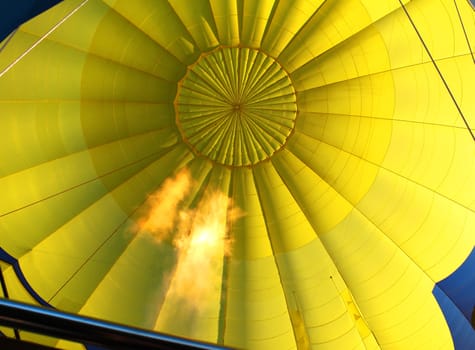 Yellow  hot air balloon inflated with open propane flame