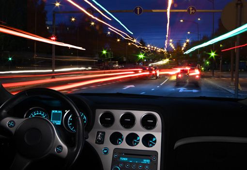 Night view of moving city lights in traffic seen from car cabin