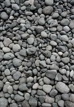 Numerous gray round pebble stones texture background