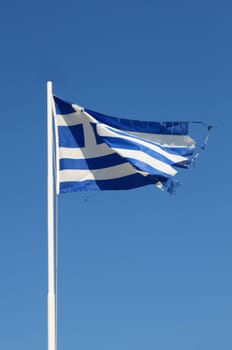 Ragged flag of Greece waving in wind vertical