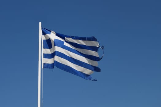 Ragged flag of Greece waving in wind horizontal