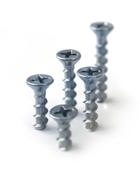 Five steel screws drilled in white background