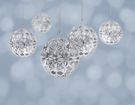 Shiny silver Christmas ball hanging on light blue background