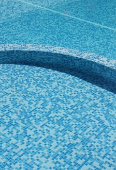 Swimming pool with clear water and turquoise mosaic pattern bottom