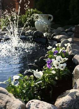 Violet flowers flourishing near garden fountain